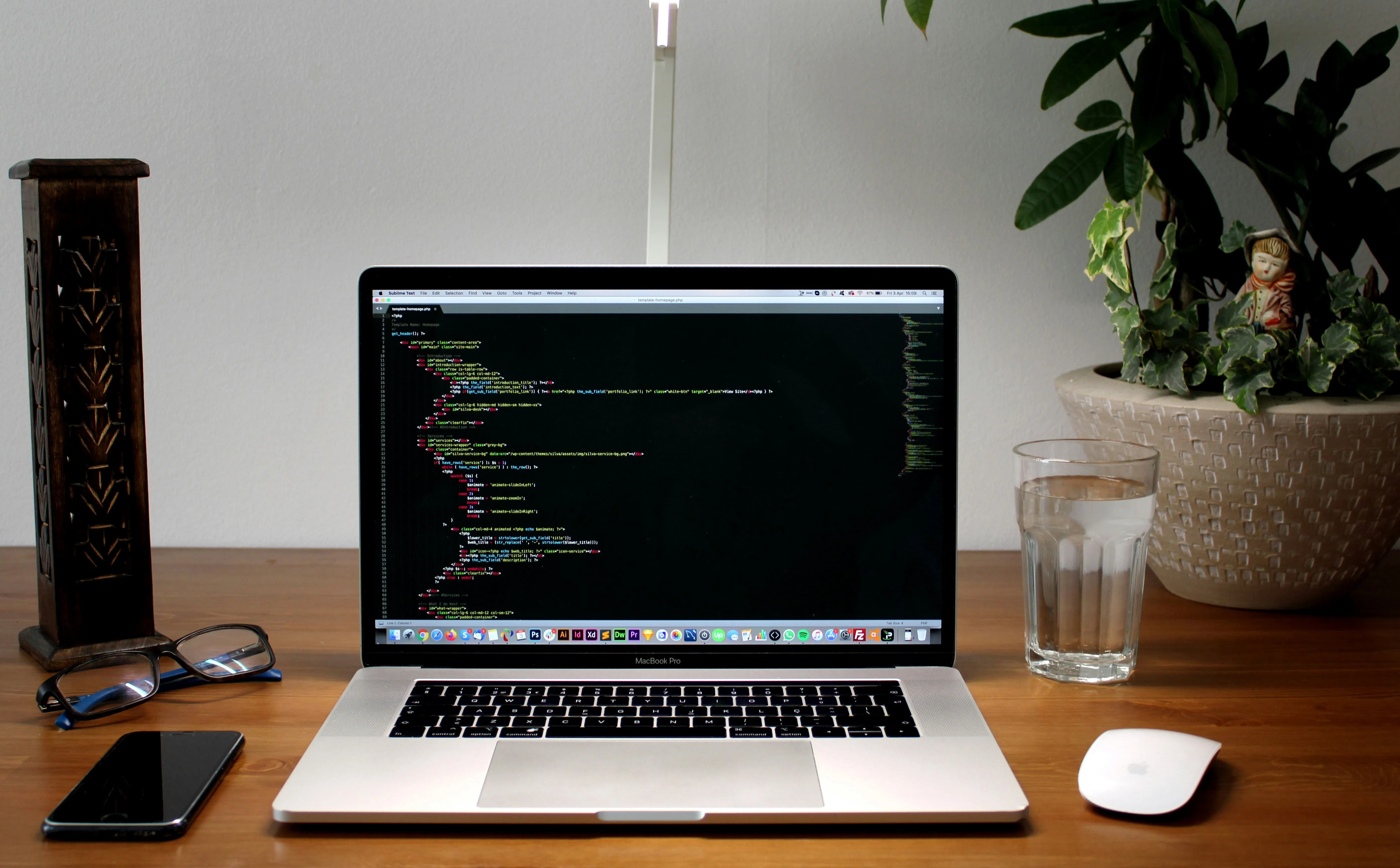 Un ecran de laptop afișând o linie de cod, cu un pahar cu apă lângă, simbolizând decizia unui dezvoltator de a reconstrui totul de la zero.