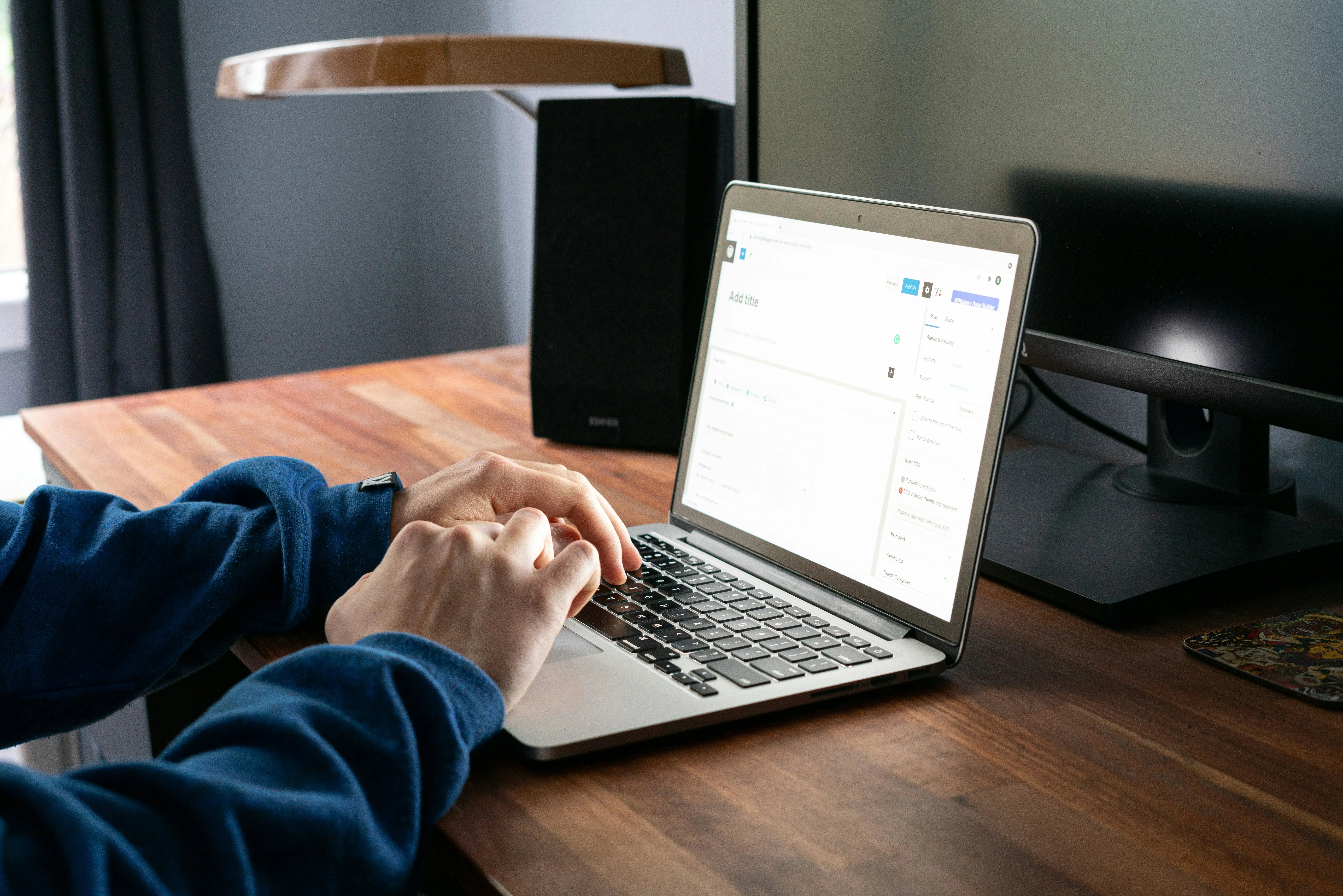 O mână tastând pe laptop cu o semnătură de email profesională afișată pe ecran